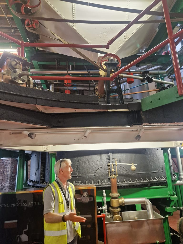 Fuller's tour guide talks about the original Fuller's brewery infront of the original mash tun